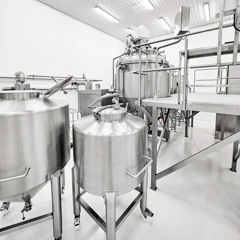 Stainless steel skincare manufacturing tanks in a clean, modern laboratory setting